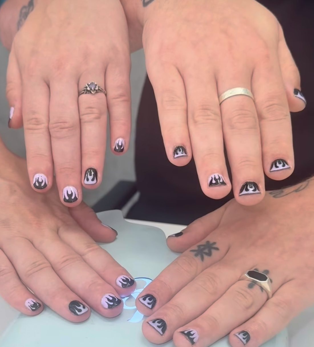 Twee handen met zwart-witte handgeschilderde nailart
